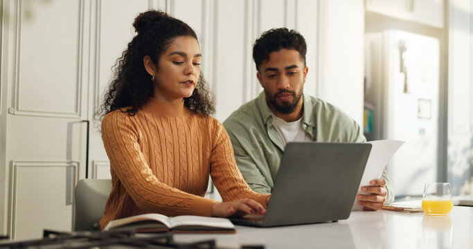 Laptop, documents and typing with couple in kitchen for bills, home loan and financial planning. Online banking, paperwork and budget review with man and woman reading in house for application - Powered by Adobe