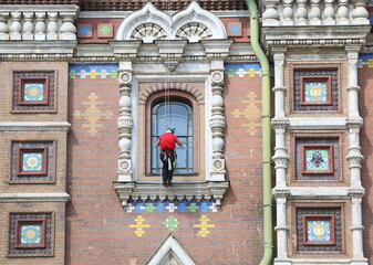 A commercial climber repairs the walls of an Orthodox church, Church of the Savior on Spilled...