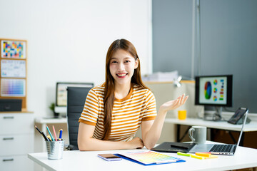 Smiling young professional confidently presents creative ideas in a modern office, showcasing...