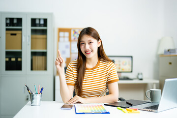 Smiling young professional confidently presents creative ideas in a modern office, showcasing...