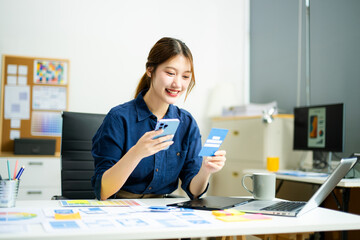 Creative designer stands at her workspace, planning UX/UI with color swatches and wireframes