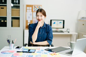 designer gestures confidently at her creative workspace, showcasing positivity, communication, and professional energy
