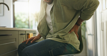 Hands, man and back pain in kitchen at house for muscle tension, bad posture and joint strain. Male...