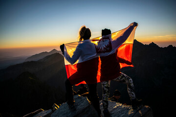 girls with the Polish flag admire the sunrise
