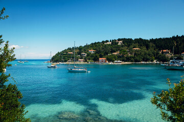 Tranquil Bay with Sailboats and Lush Green Hills