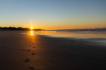 Footprints on the beach at sunrise