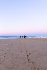 Family walking at sunrise on a deserted beach