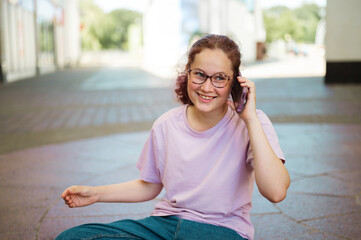 Teen age with eyeglasses talking on phone in the street