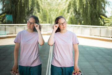 Teenage girl and her reflection in the mirror surface of a building