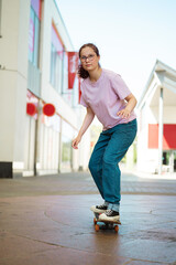 Young teenage girl riding skateboard in the city