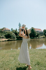 Mother lifting baby in polka dot outfits near lake