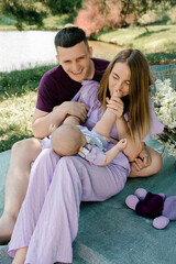 Young parents laughing with baby during picnic