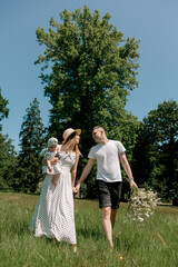 Young family walking with baby and flowers outside