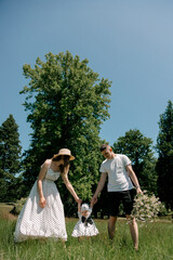 Parents holding baby girl between them outdoors