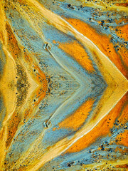 close-up of a textured multicolored sand surface. The image is highly detailed, with varying shades...