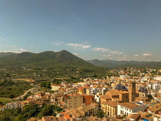 Fototapeta premium aerial image of a part of the city surrounded by mountains and pine forests