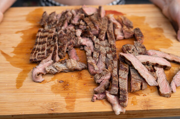 Grilled steak slices on wooden cutting board with juices visible. National Mincemeat Day