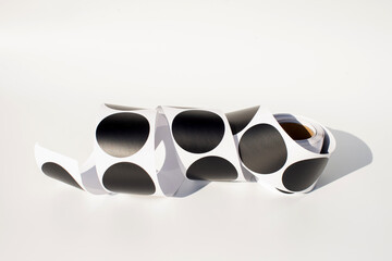 Roll of black circle stickers on white background with shadows