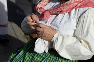 human hands sewing with metal thimble