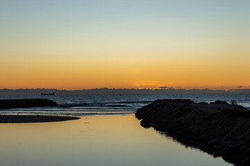 image of the sea at dawn next to the breakwaters where the river flows into the sea. © Ernesto López  