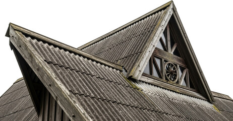 Close up of a weathered corrugated metal roof on an old building with a wooden gable window detail...