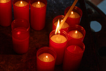 red candles being lit as an offering, religious concept