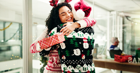 Christmas, gift and business people hug in office for holiday, tradition and celebration....