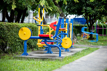 View of The yellow, red, blue exercise machine on the lawn at the park, focus selective
