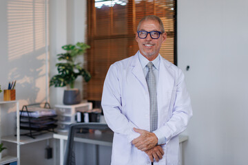Healthcare, medical staff concept. Portrait of smiling male doctor posing with folded arms on free...