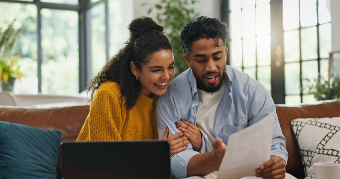 Happy, hug and couple with paperwork, home loan or excited for financial planning on website or app. Laughing, man and woman with document for mortgage, laptop and celebration with embrace in house - Powered by Adobe