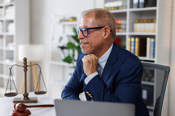 Portrait of an attractive, successful, influential, Law adult caucasian manager, businessman or lawyer in stylish formal suit, sitting at work desk in the office, looks at the camera friendly smiling
