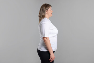 Weight loss. Plus size woman on gray background