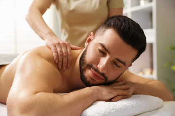 Man receiving relaxing massage in spa salon