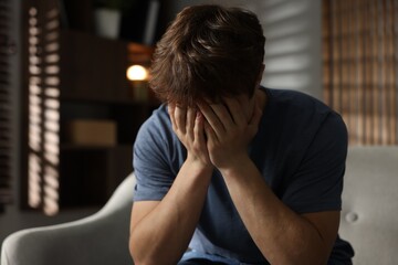 Teen problems. Depressed teenage boy on sofa at home