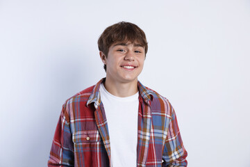 Portrait of smiling teenage boy on light grey background
