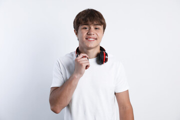Portrait of smiling teenage boy with headphones on light grey background