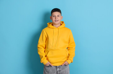 Portrait of teenage boy on light blue background