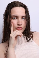 Portrait of beautiful woman with natural skin complexion on light grey background, closeup