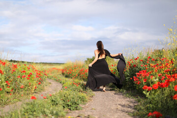 Woman running in beautiful wildflower meadow, back view