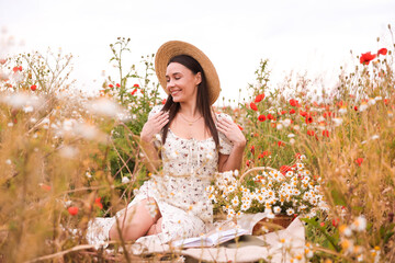 Smiling woman in hat posing in wildflower meadow