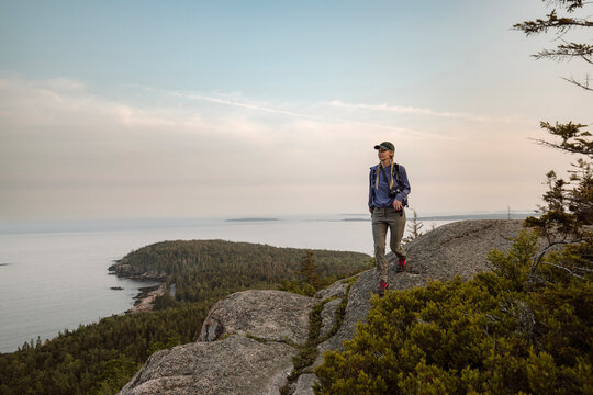 Solo woman hikes along ridge with view, Acadia National Park, Maine