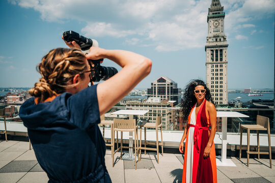 Photographer captures model in red dress on sunny Boston rooftop