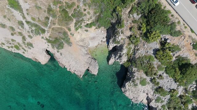 Beautiful Young Woman in Bikini Swims in Stara Baska Beach Krk Island, Croatia. Mediterranean Summer. Aerial Shot From Above. Blue Sea the Rocks Mountains and Coastline Calm Sea With Clear Blue Water