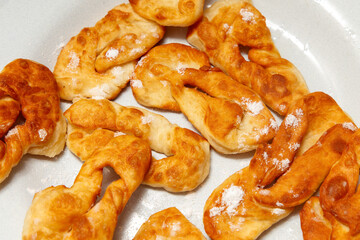 A plate of fried doughnuts with powdered sugar on top