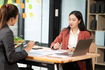 Fototapeta premium Two Asian businesswomen have a meeting in the office.