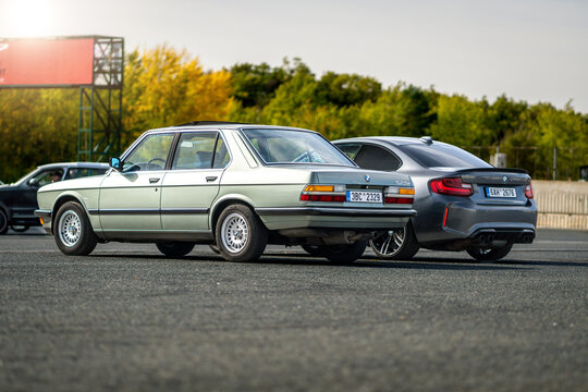 New and old BMW M luxury car parked next to each other outside in a parking lot. Fast sports cars made in Germany.