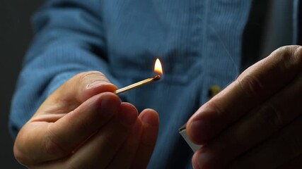 A close-up of a flaming match in the guy’s hands.
Flammable objects and starting a fire with a wooden match.
Bright blazing fire lit by a match