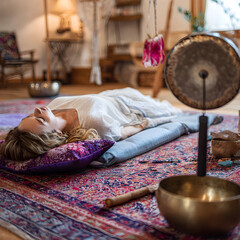 Woman relaxing on floor during sound healing therapy session