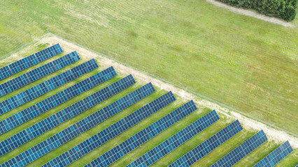 Rows of solar panels capturing sunlight in green field