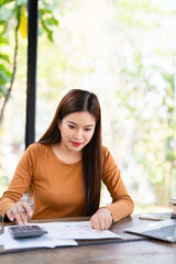 Focused young asian woman work on laptop manage household finances expenditures. Concentrated...